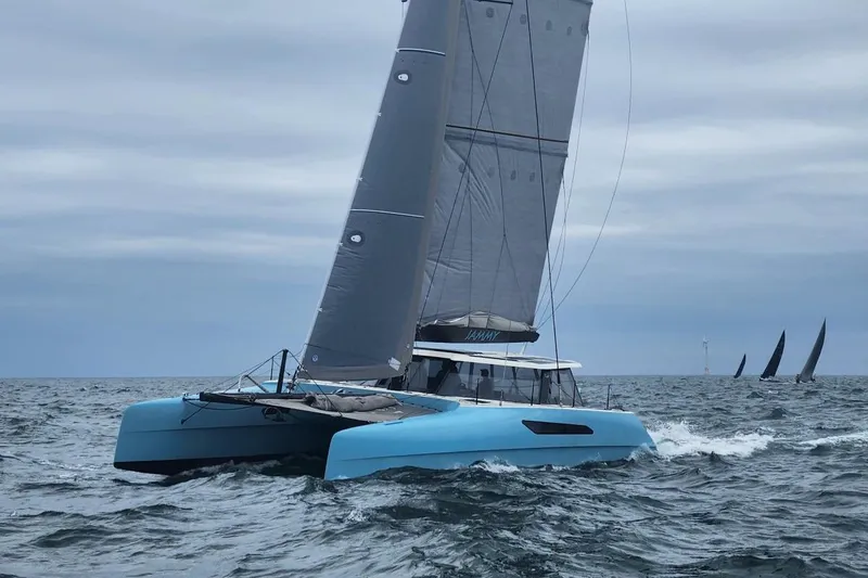 The Image of 2015 Gunboat 57' catamaran sailing on open sea with overcast sky. - 0