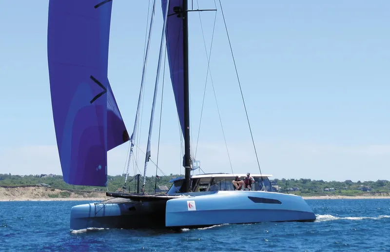 Slide: The Image of 2015 Gunboat 57' catamaran sailing with purple sails on open water. - 1