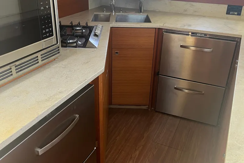 Slide: The Image of Modern kitchen in 2015 Gunboat 57' yacht with stainless steel appliances and wood flooring. - 14