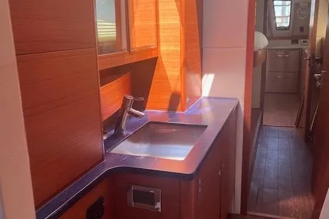 Slide: The Image of Interior of 2015 Gunboat 57' yacht featuring a modern kitchen sink and wooden cabinetry. - 23