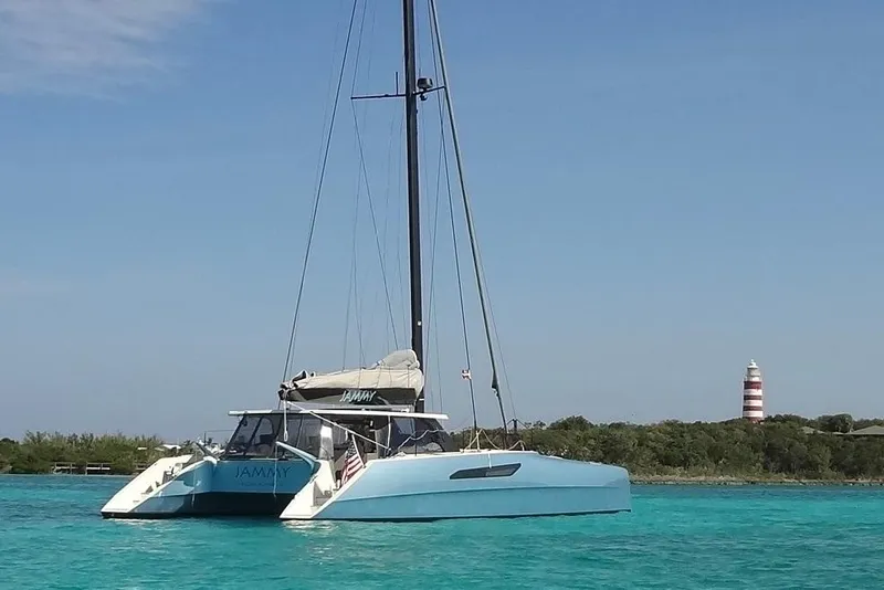 Slide: The Image of 2015 Gunboat 57' catamaran sailing near a lighthouse in clear blue waters. - 29