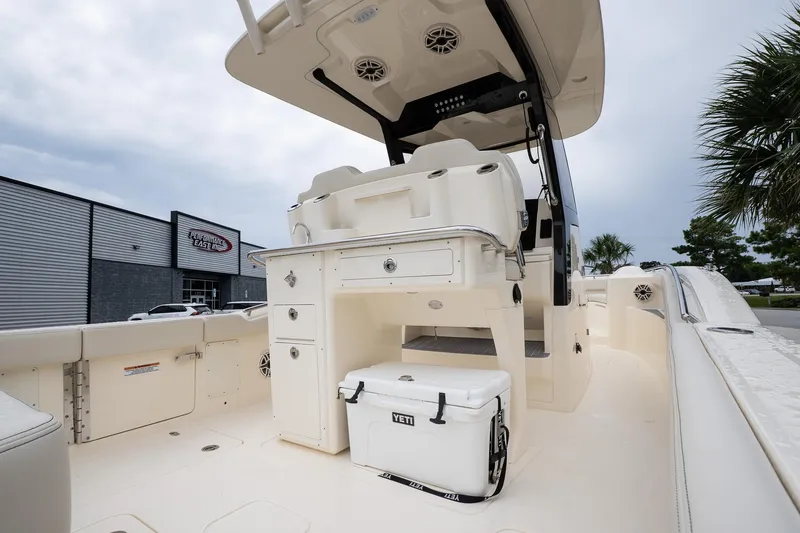 Slide: The Image of 2026 Scout 288 LXF boat interior with seating, storage, and cooler, near dealership. - 10