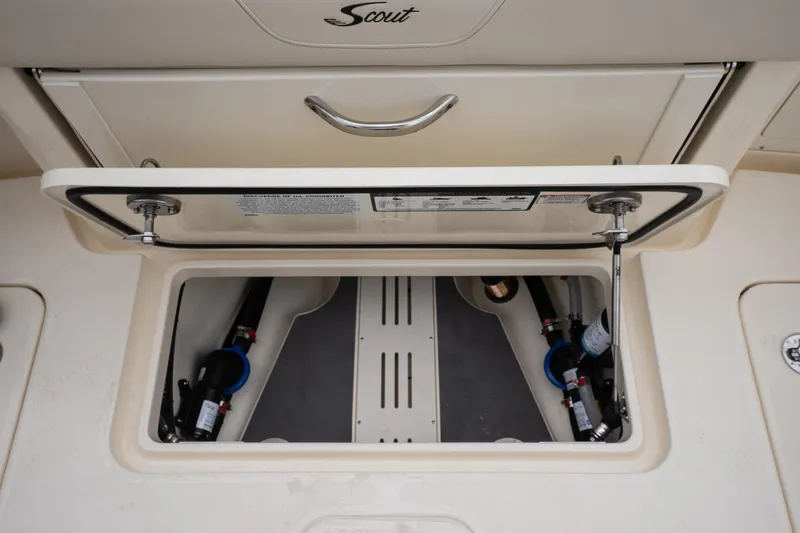 Slide: The Image of 2026 Scout 288 LXF boat storage compartment with open hatch and visible plumbing. - 17