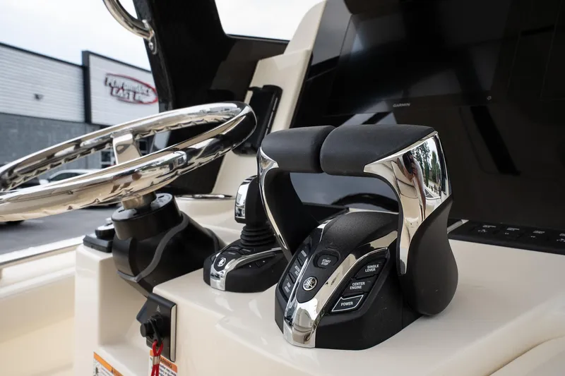 Slide: The Image of 2026 Scout 288 LXF boat helm with steering wheel and throttle controls. - 23