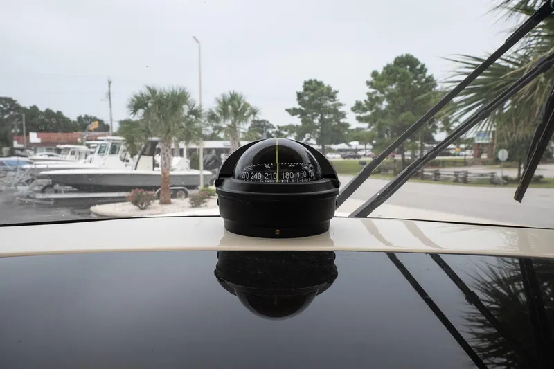 Slide: The Image of Compass on 2026 Scout 288 LXF boat dashboard, marina background with palm trees. - 26