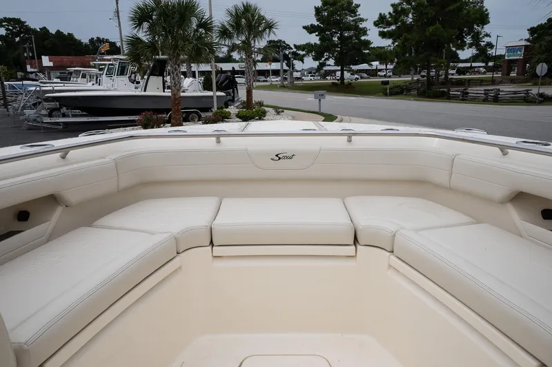 Slide: The Image of 2026 Scout 288 LXF boat interior with white seating, docked near palm trees. - 27