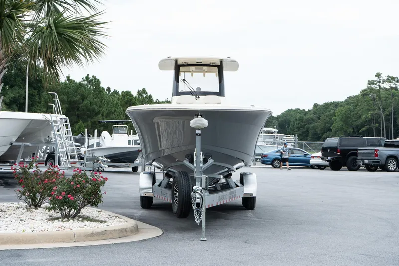 Slide: The Image of 2026 Scout 288 LXF boat on trailer in parking lot, surrounded by trees and vehicles. - 3