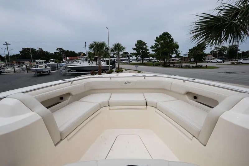 Slide: The Image of 2026 Scout 288 LXF boat with spacious seating, docked outdoors under cloudy skies. - 30