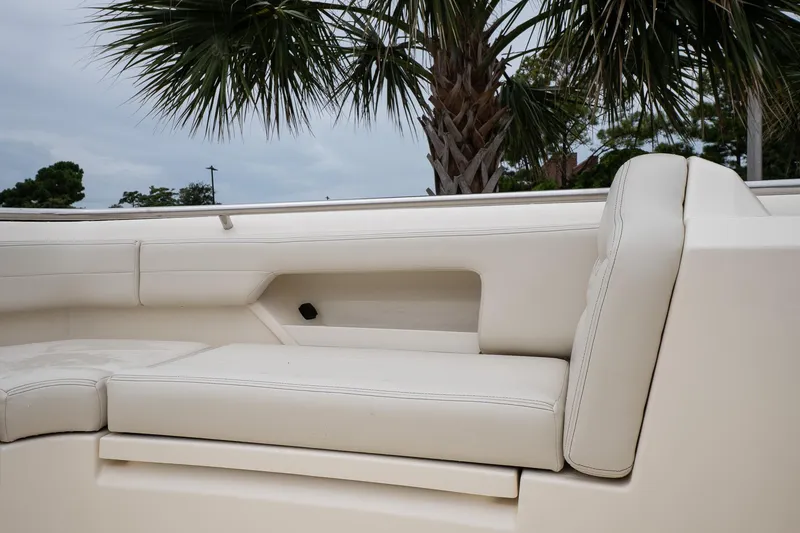 Slide: The Image of 2026 Scout 288 LXF boat interior with white seating and palm tree background. - 32