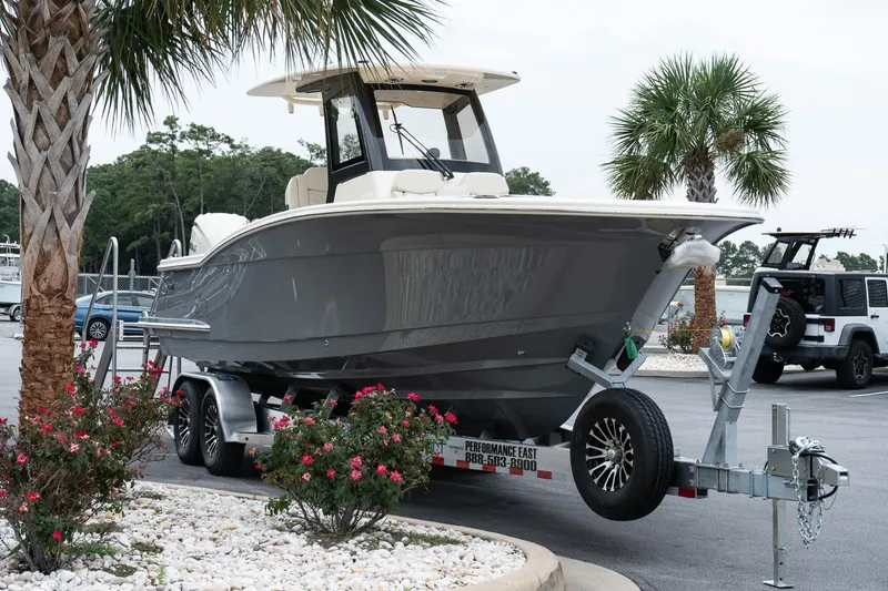 Slide: The Image of 2026 Scout 288 LXF boat on trailer, surrounded by palm trees and flowers. - 4