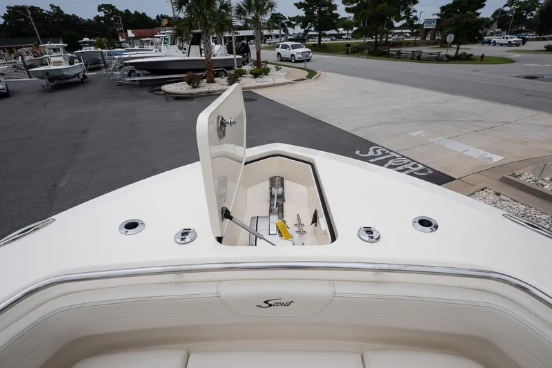 Slide: The Image of 2026 Scout 288 LXF boat with open anchor hatch in a marina setting. - 43
