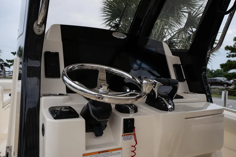 Slide: The Image of 2026 Scout 288 LXF boat helm with modern steering wheel and controls. - 48