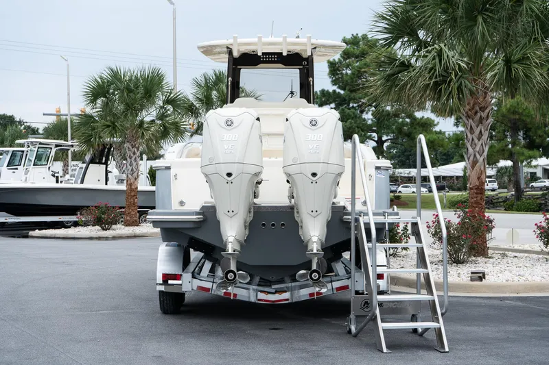 Slide: The Image of 2026 Scout 288 LXF boat with dual outboard engines on a trailer, surrounded by palm trees. - 6
