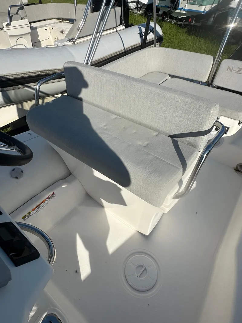 Slide: The Image of 2023 Zodiac N-ZO 680 boat interior with cushioned seating and steering area. - 11