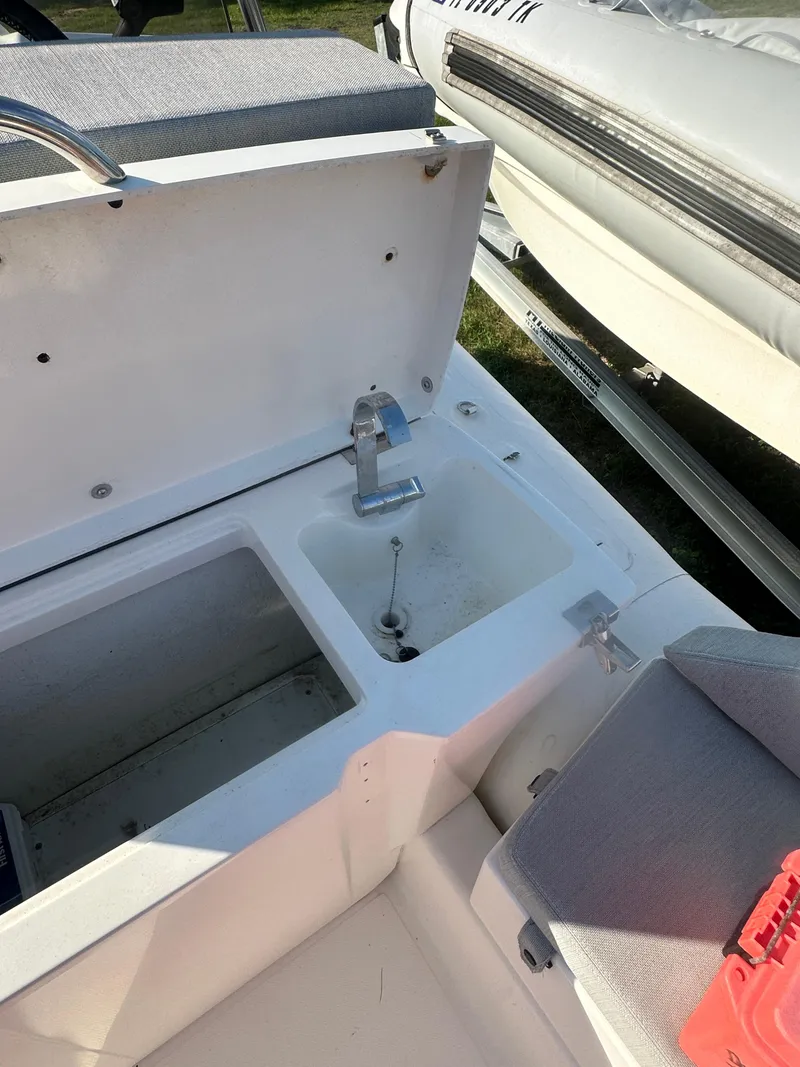 Slide: The Image of 2023 Zodiac N-ZO 680 boat interior with open storage compartment and sink. - 12