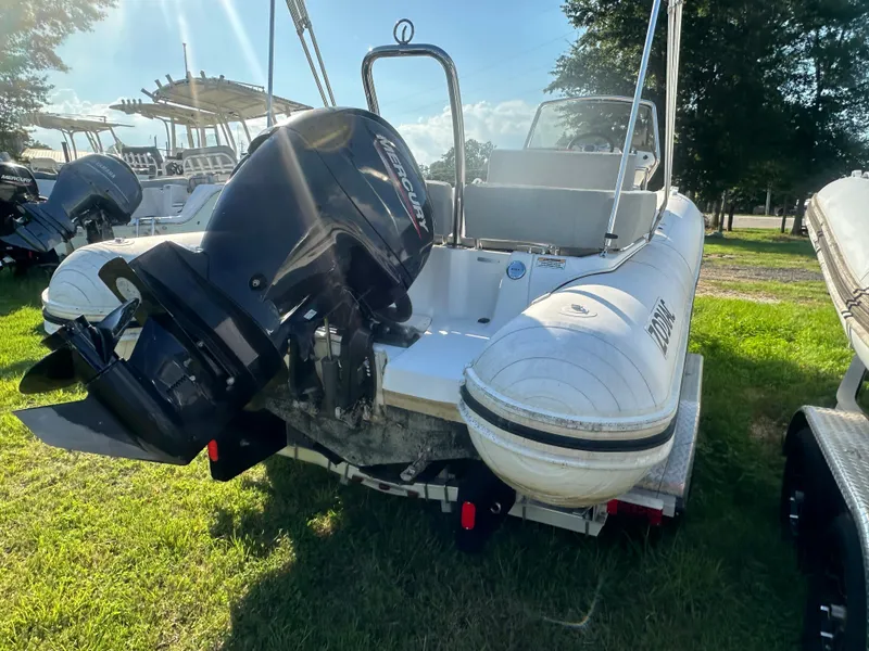 Slide: The Image of 2023 Zodiac N-ZO 680 boat with Mercury outboard motor, parked on grass. - 3
