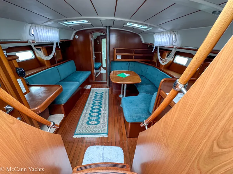 Slide: The Image of Interior of 1999 Beneteau 411 yacht with wooden finish and teal seating. - 14