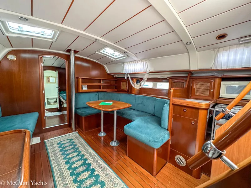 Slide: The Image of Interior of 1999 Beneteau 411 yacht with wooden finish and teal seating. - 15