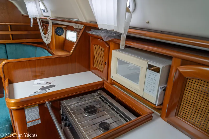 Slide: The Image of Interior of a 1999 Beneteau 411 yacht with kitchen amenities and seating area. - 18