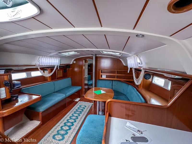 Slide: The Image of Interior of 1999 Beneteau 411 yacht with teal seating and wooden finishes. - 19