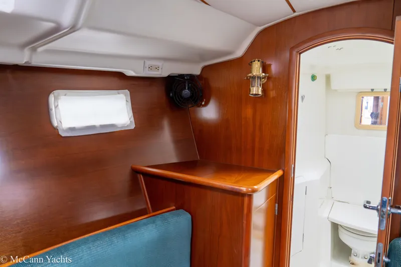 Slide: The Image of Interior of 1999 Beneteau 411 yacht showing wooden cabinetry and compact bathroom. - 22