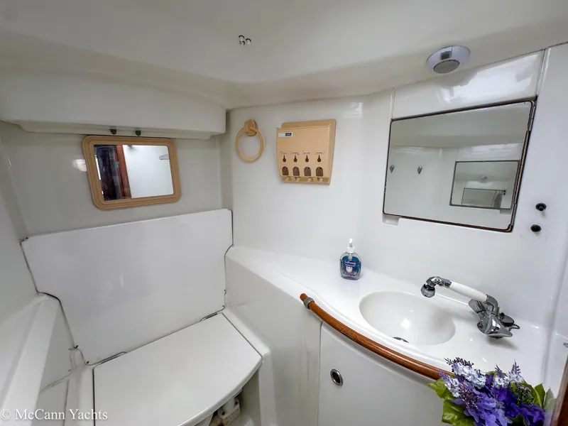 Slide: The Image of Bathroom interior of 1999 Beneteau 411 yacht with sink, mirror, and storage. - 24