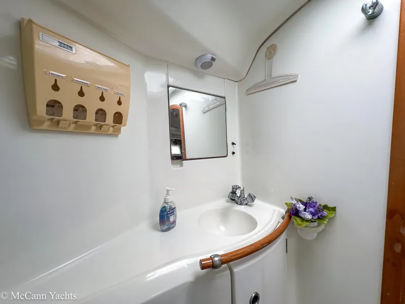 Slide: The Image of Bathroom interior of a 1999 Beneteau 411 yacht, featuring a sink and mirror. - 25