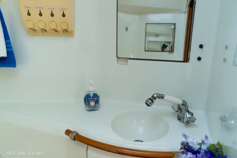 Slide: The Image of Bathroom sink area on a 1999 Beneteau 411 yacht with soap dispenser and mirror. - 26