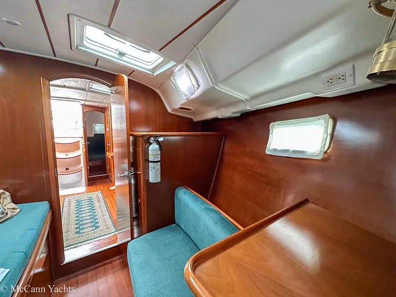 Slide: The Image of Interior of a 1999 Beneteau 411 yacht with wood paneling and blue seating. - 29