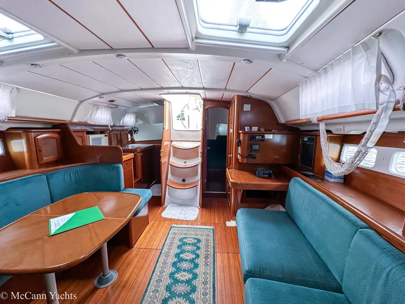 Slide: The Image of Interior of 1999 Beneteau 411 yacht with wood finish and teal seating. - 30