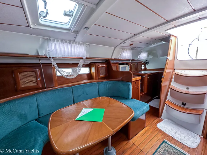 Slide: The Image of Interior of a 1999 Beneteau 411 yacht with wooden furnishings and teal seating. - 31