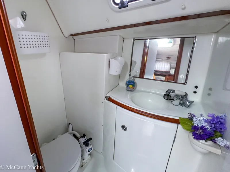 Slide: The Image of Compact bathroom in 1999 Beneteau 411 yacht with sink, mirror, and toilet. - 32