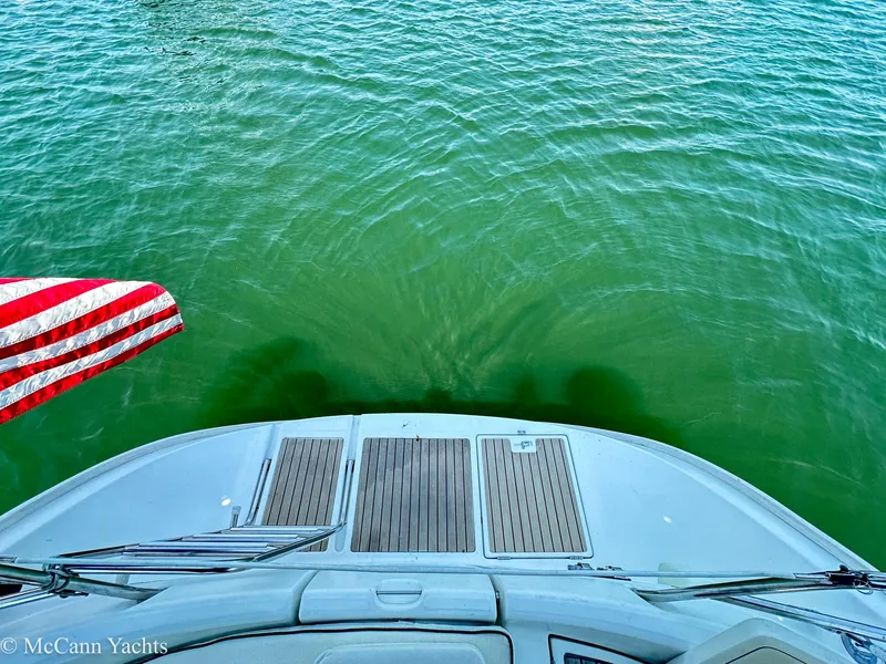 Slide: The Image of Beneteau 411 yacht stern view with American flag, 1999 model, on calm green water. - 35