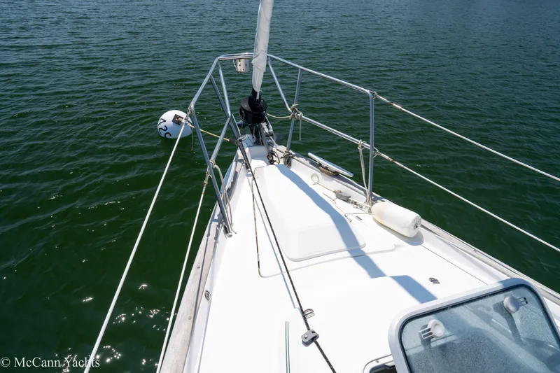 Slide: The Image of Bow of 1999 Beneteau 411 sailboat on calm water, featuring deck and railing. - 42