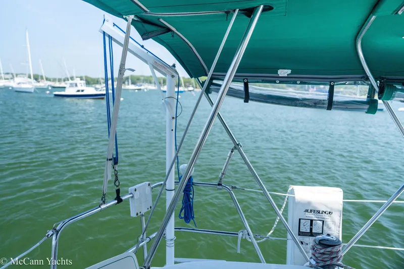 Slide: The Image of Sailboat deck view, Beneteau 411, 1999 model, with green canopy and marina background. - 47