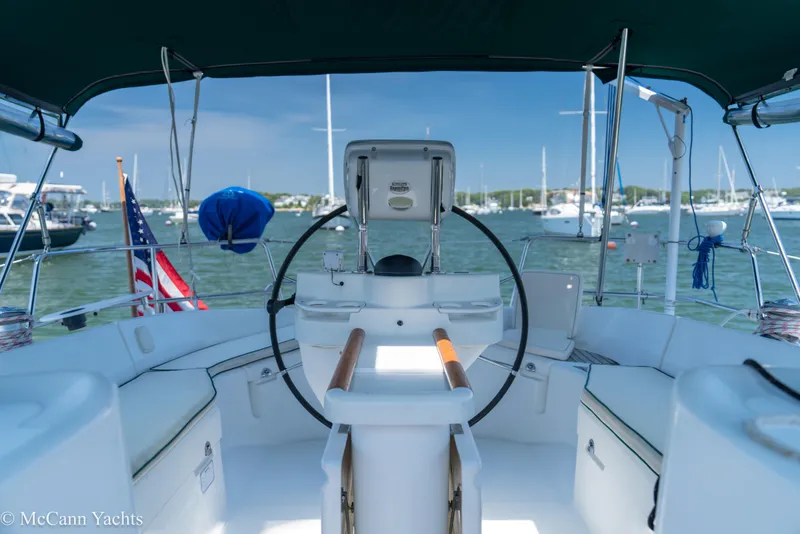 Slide: The Image of Cockpit view of a 1999 Beneteau 411 sailboat in a marina setting. - 49