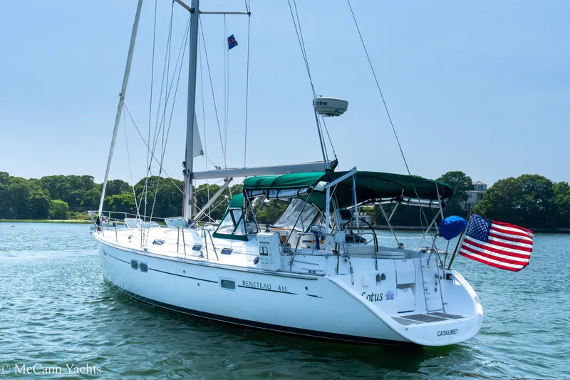 Slide: The Image of Sailing yacht Beneteau 411, 1999 model, with American flag, anchored in serene waters. - 6