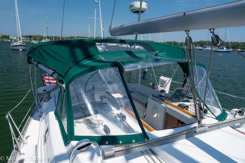 Slide: The Image of Sailboat Beneteau 411 (1999) with green canopy, docked in a marina. - 7