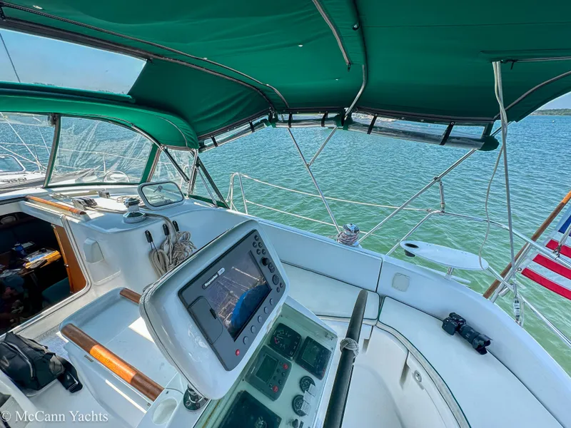 Slide: The Image of Cockpit view of 1999 Beneteau 411 sailboat with navigation equipment and green canopy. - 9