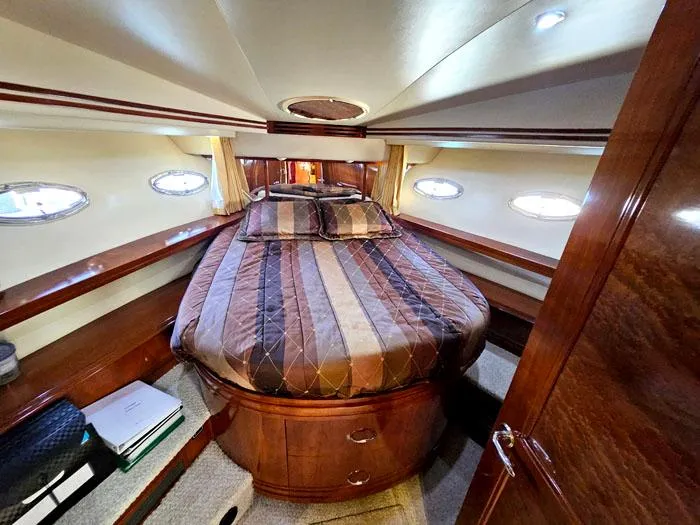 Slide: The Image of Luxurious 2004 Carver 560 Voyager PH yacht bedroom with elegant wood finish and cozy bedding. - 21