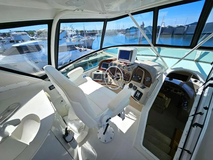 Slide: The Image of 2004 Carver 560 Voyager PH helm with modern controls and marina view. - 24