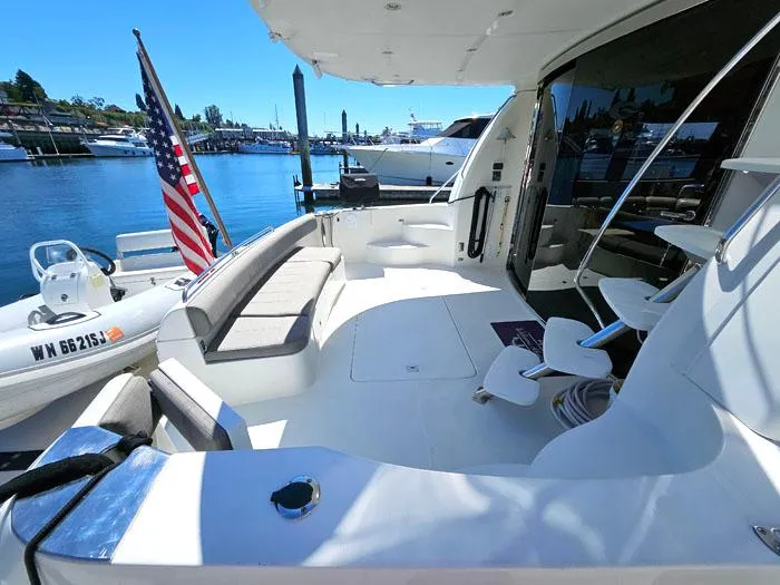 Slide: The Image of 2004 Carver 560 Voyager PH yacht deck with seating, docked by the water. - 4