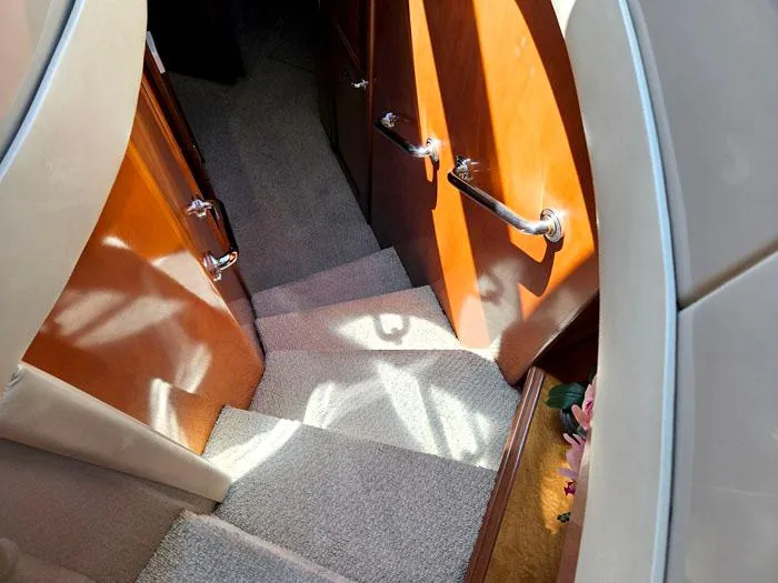 Slide: The Image of Staircase inside 2004 Carver 560 Voyager PH yacht with wooden handrails and carpeted steps. - 14