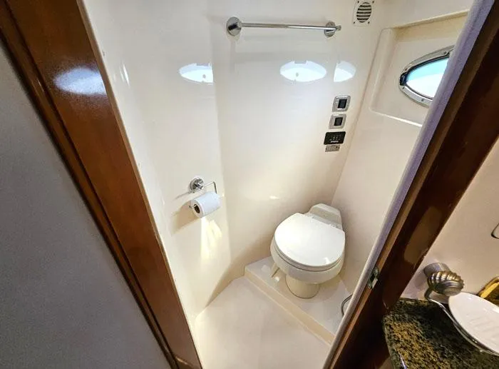 Slide: The Image of Compact bathroom in 2004 Carver 560 Voyager PH yacht with toilet and porthole window. - 19