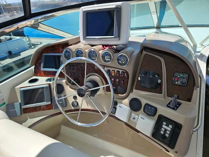 Slide: The Image of 2004 Carver 560 Voyager PH helm with steering wheel, gauges, and navigation screens. - 25