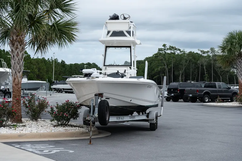 Slide: The Image of 2019 Robalo 246 Cayman SD boat on trailer, parked near palm trees. - 12