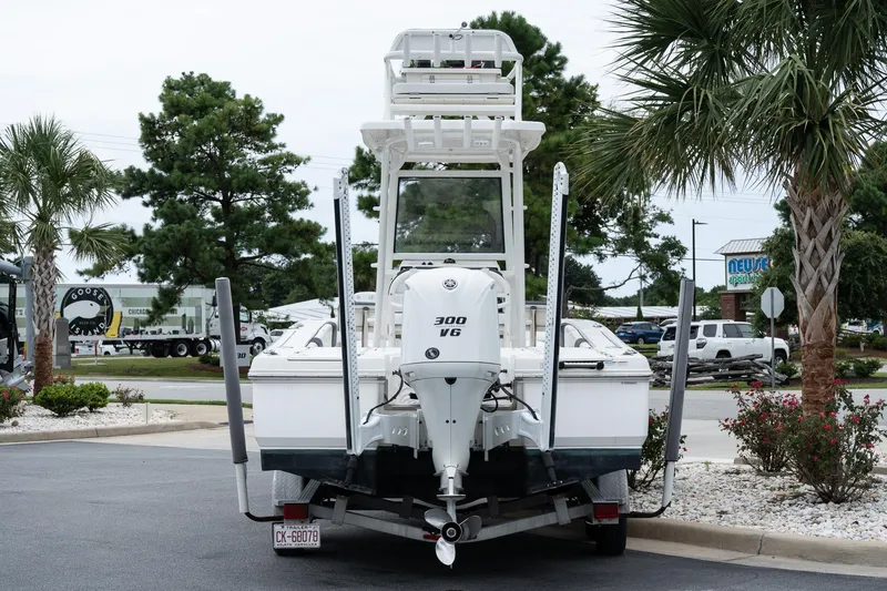Slide: The Image of 2019 Robalo 246 Cayman SD boat on trailer, rear view, parked near palm trees. - 15