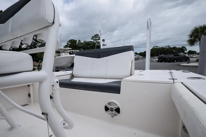 Slide: The Image of 2019 Robalo 246 Cayman SD boat interior with seating and speaker, parked outdoors. - 21