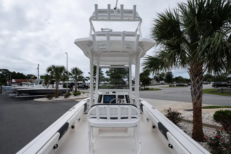 Slide: The Image of 2019 Robalo 246 Cayman SD boat with T-top, parked near palm trees. - 22