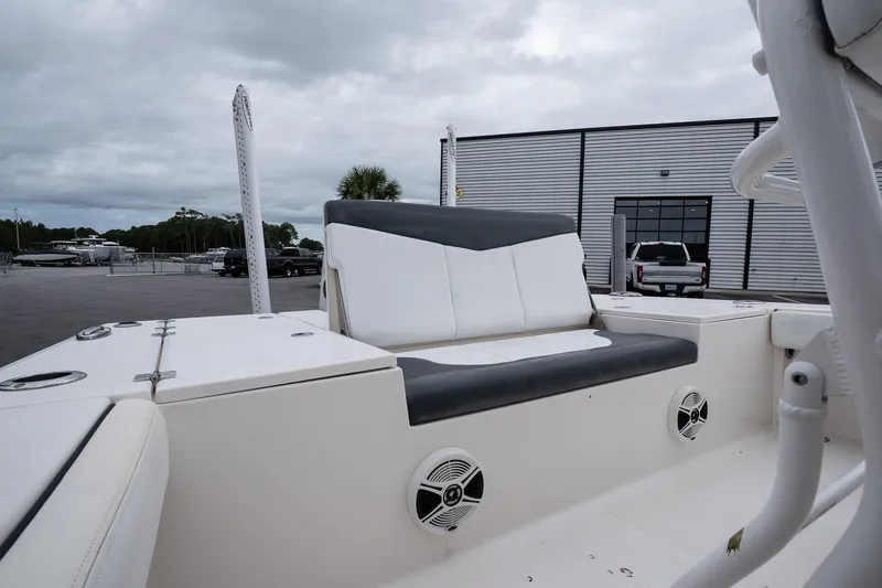 Slide: The Image of 2019 Robalo 246 Cayman SD boat interior with seating and speakers, docked near a building. - 23